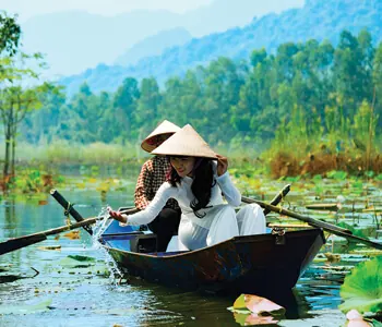A couple in a rowing boat on a green river